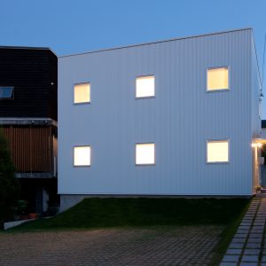 互い違いの内壁/homeHR 北西からの外観(夕景)