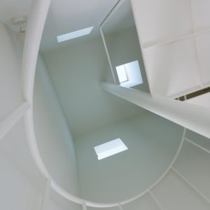 互い違いの内壁/homeHR 階段室を見上げる