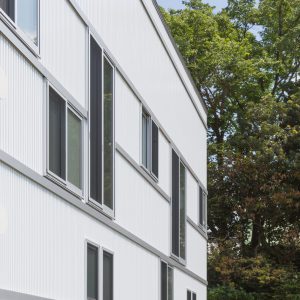 六層二階建ての窓/リナスト障がい者福祉施設 敷地の南側には神社の杜が広がる