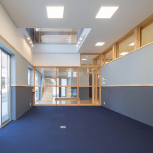 六層二階建ての窓/リナスト障がい者福祉施設 事務室からエントランスホールを見る