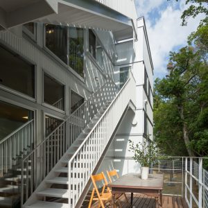 六層二階建ての窓/リナスト障がい者福祉施設 南側ウッドデッキと屋外階段